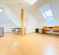 Büros mit Holzboden, Dachfenster, Tische und Stühle.