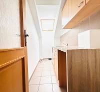 Schmale Küchenzeile im Büro mit Fenster und Boden in Holzoptik.