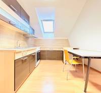 Büros mit Küche und Esstisch, heller Boden mit Holzdekor.