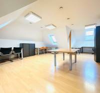 Dachgeschossbüros mit Holzboden, Dachfenstern und Büroausstattung.