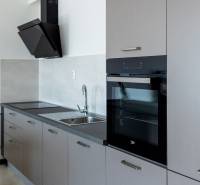 Küche mit linearer Küchenzeile und eingebautem Ofen in einer 3-Zimmer-Wohnung.