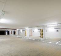 Unterirdischer Parkplatz mit heller Beleuchtung und reservierten Parkplätzen.