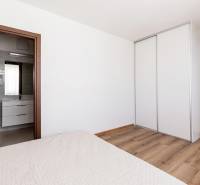 Schlafzimmer in einer 3-Zimmer-Wohnung mit Holzboden und Einbauschrank.