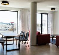 Wohnzimmer in einer 3-Zimmer-Wohnung mit Esstisch und Blick auf die Stadt.