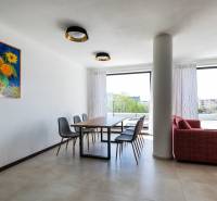 Esszimmer in einer 3-Zimmer-Wohnung mit einem Bild von Sonnenblumen, einem Boden in Holzoptik und Blick auf die Terrasse.