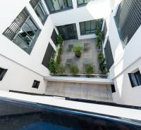 Innenhof des Wohnkomplexes in Nitra mit Terrassenpflaster und Grünflächen.