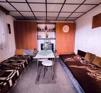 Interieur der Hütte mit Betten, Tisch, Schränken und Dekorationen.