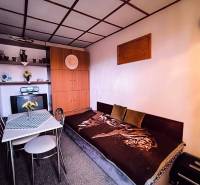 Das Innere der Hütte mit einem Sofa, einem Esstisch und einem Einbauschrank wird von einer natürlichen Farbpalette dominiert.