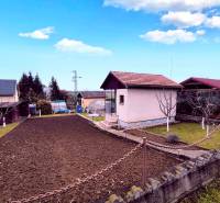 Das Äußere der Hütte in Partizánske mit gepflegtem Garten, Rasen und Blumenbeet.