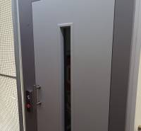 Graue Tür mit Glasfenster und Aufzugknopf, Foto in einem Einzimmerapartment.