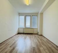 Ein Büro mit großen Fenstern und einem Boden in Holzoptik.