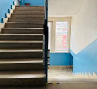 Treppe im Innenbereich des Büros mit blauen Wänden und hellen Fliesen.