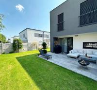 Einfamilienhaus in Rovinka mit Terrasse, grünem Rasen und Außenbereich zum Sitzen.