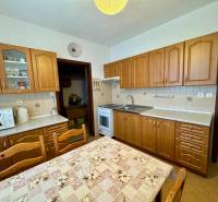 Küche mit Holzschränken und Esstisch, geeignet für eine 3-Zimmer-Wohnung.