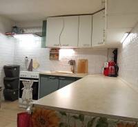 Küche in einem Einfamilienhaus mit weißen Ziegelwänden und Küchengeräten.