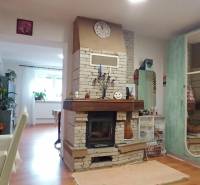 Innenraum eines Einfamilienhauses mit Kamin und Bodenbelag in Holzoptik, ergänzt durch eine bunte Dekoration.