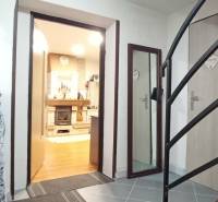 Innenraum eines Einfamilienhauses mit Treppe, Holzboden und Kamin.