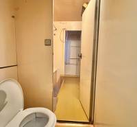 Badezimmer mit Toilette in einer 3-Zimmer-Wohnung, beige Wände, gelber Boden.