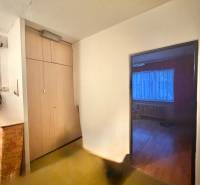 Flur mit Einbauschrank in einer 3-Zimmer-Wohnung, Eingang zum Zimmer mit Holzboden.