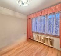 Ein Zimmer in einer 3-Zimmer-Wohnung mit einem Boden in Holzoptik und Vorhängen.