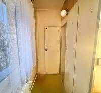 Ein enger Flur in einer 3-Zimmer-Wohnung mit Bodenbelag und weißen Türen.