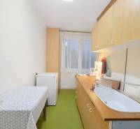 Küche in einer 3-Zimmer-Wohnung mit einfacher Einrichtung, Boden mit Holzdekor.