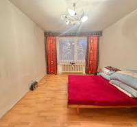 Schlafzimmer in einer 3-Zimmer-Wohnung mit Bett, Holzboden und Licht.