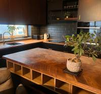 Küche in einer 2-Zimmer-Wohnung mit Holzboden und schwarzer Küchenzeile.