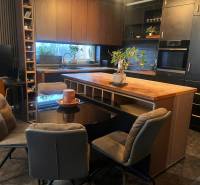 Küche in einer 2-Zimmer-Wohnung mit schwarzen Schränken und einem Boden in Holzoptik.