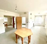 Ein geräumiges Zimmer mit Holztischen und Heizkörpern in einem Einfamilienhaus.