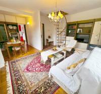 Das Innere der Hütte mit einer Wendeltreppe, einem Fernseher und einem Tisch auf einem Boden mit Holzdekor.