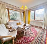 Helles Wohnzimmer mit Holzdekorboden, Teppich, weißen Möbeln, großen Fenstern.