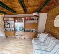 Innenraum einer Hütte mit Holzbalken, Möbeln und einem Boden mit Holzdekor.