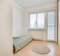 Einfaches Zimmer mit Holzboden und einem ausziehbaren Bett in einer 4-Zimmer-Wohnung.