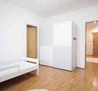 Helles Zimmer mit Bett, Schrank und Boden in Holzoptik in einer 4-Zimmer-Wohnung.