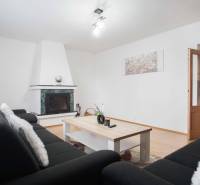 Wohnzimmer in einer 4-Zimmer-Wohnung mit Kamin und Boden in Holzoptik.