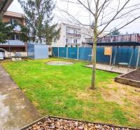 Garten bei einer 4-Zimmer-Wohnung in Kolta, mit Grünflächen, Gehweg und Schaukel.