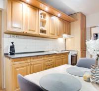 Küche in einer 4-Zimmer-Wohnung mit Holzschränken, Blumen und Esstisch.