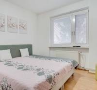 Schlafzimmer in einer 4-Zimmer-Wohnung mit Blumendekorationen und einem Fernseher an der Wand.