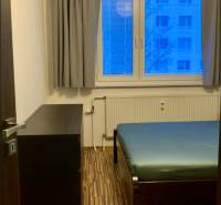 Schlafzimmer in einer 3-Zimmer-Wohnung mit Bett, Kommode und Bodenbelag in Holzoptik.
