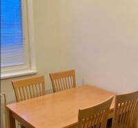 Esstisch mit vier Stühlen in einer 3-Zimmer-Wohnung, Boden mit Holzdekor.