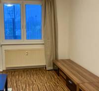 Wohnzimmer in einer 3-Zimmer-Wohnung mit Holzboden und Blick durch ein großes Fenster.