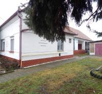 Einfamilienhaus in Kravany nad Dunajom mit Garage, daneben Gehweg und Rasenfläche.