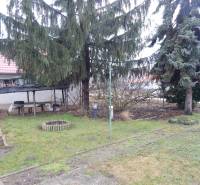 Ein Garten bei einem Einfamilienhaus in Kravany nad Dunajom mit einem Pavillon und Nadelbäumen.