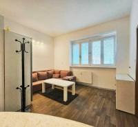 Garçonniere mit Sofa, Tisch und Holzboden.