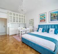 Einzimmerwohnung mit Holzboden, Bett und weißen Küchenschränken.