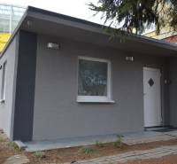 Ein Ferienhaus mit grauer Fassade in Bratislava - Ružinov in der Studená Straße, umgeben von Grün.