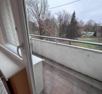 Balkon einer 2-Zimmer-Wohnung mit Blick auf die Umgebung, Fliesen, Bäume.