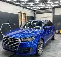 Audi SUV in Geschäftsräumen mit gefliestem Boden und geometrischen Deckenleuchten.