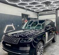 Geschäftsräume mit beleuchtetem Dach und Luxusfahrzeug.